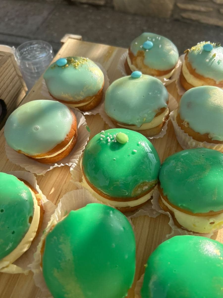 Cream-filled donuts with green glaze on a wooden base