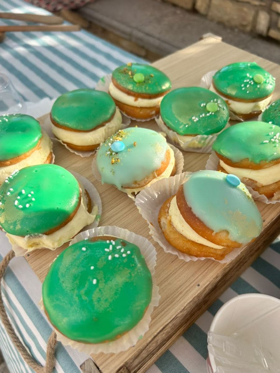 Cream-filled donuts on a wooden board over a striped cloth