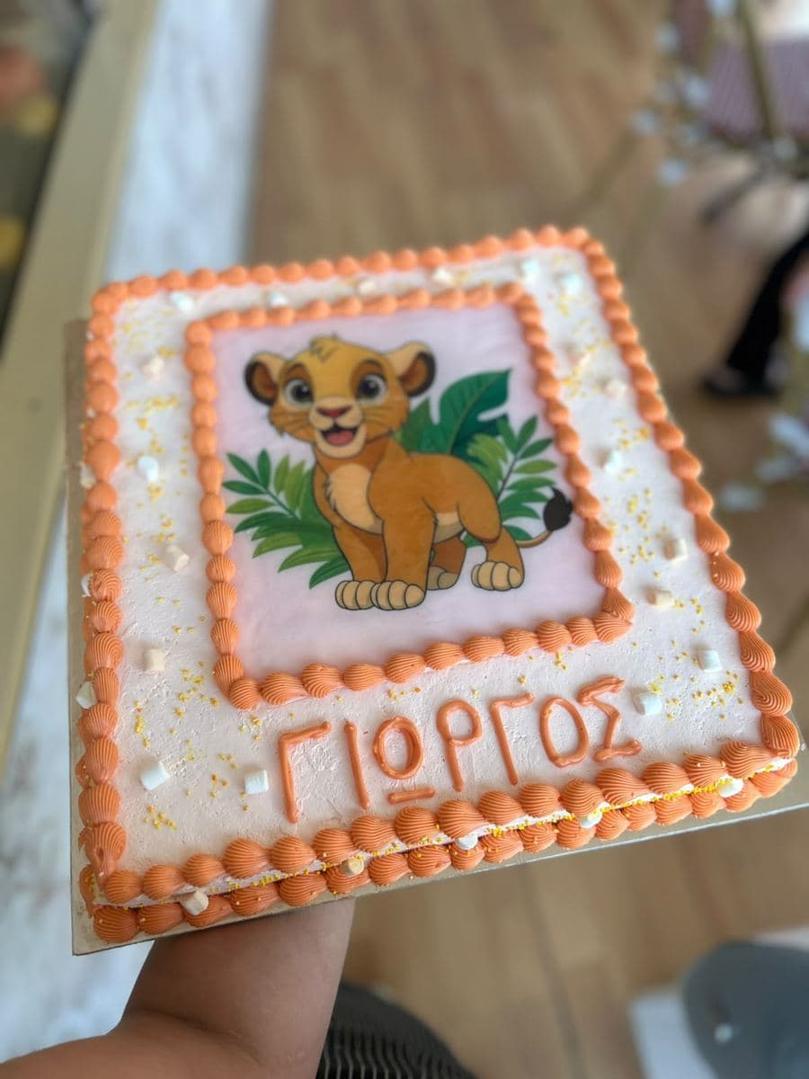 Childrens birthday cake with a printed topper and the childs name