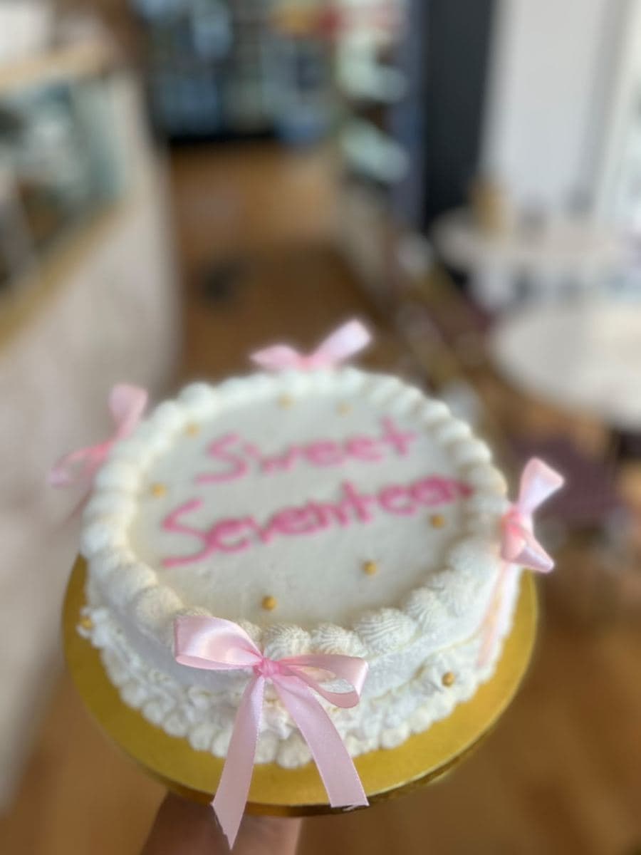 White cake with pink ribbons for a seventeenth birthday